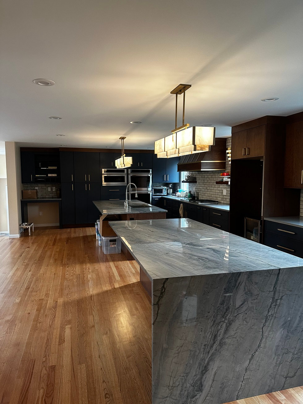 Waterfall quartz island with dark cabinetry by Pistritto Marble Imports in Hartford, CT